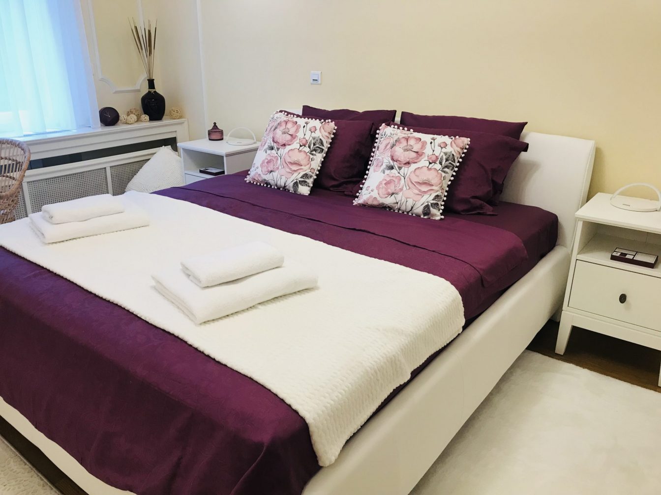Queen size bed with purple and white sheets