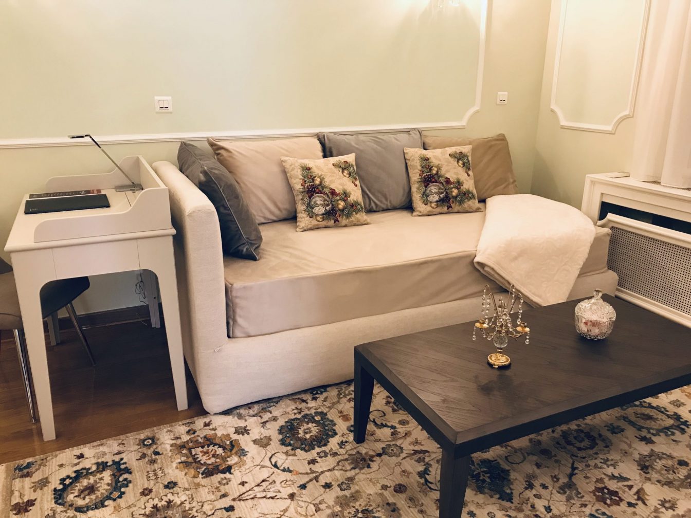 A couch, a small table and a work desk on a beautiful carpet